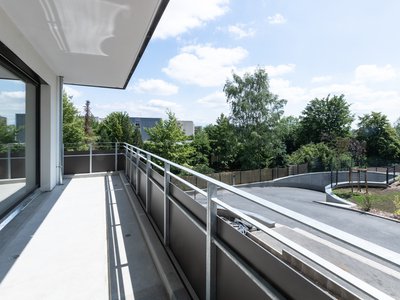 Weitläufiger Balkon mit Blick auf grüne Umgebung und Straße