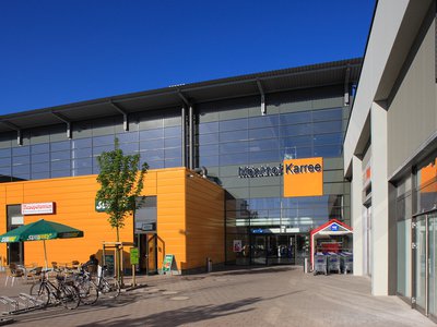Einkaufszentrum Mönkhof Karree mit orangefarbener Fassade und Glasdach