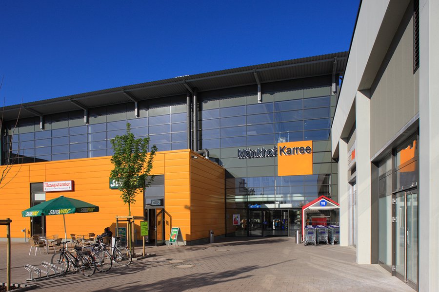 Haupteingang des Einkaufszentrums mit orangefarbener Fassade