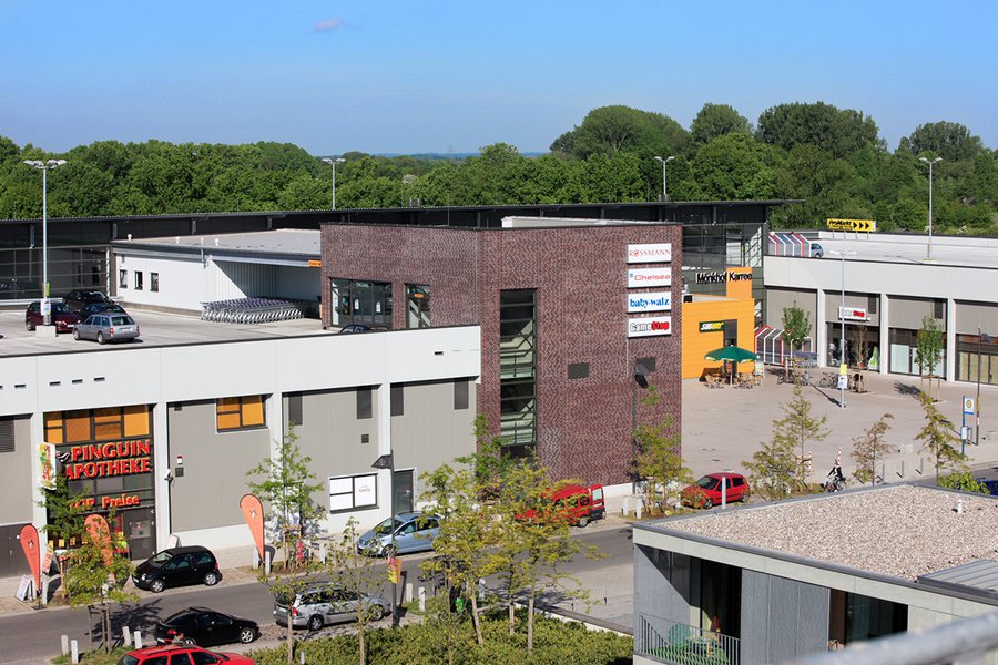 Außenansicht mit Parkplätzen und gemischter Fassadengestaltung