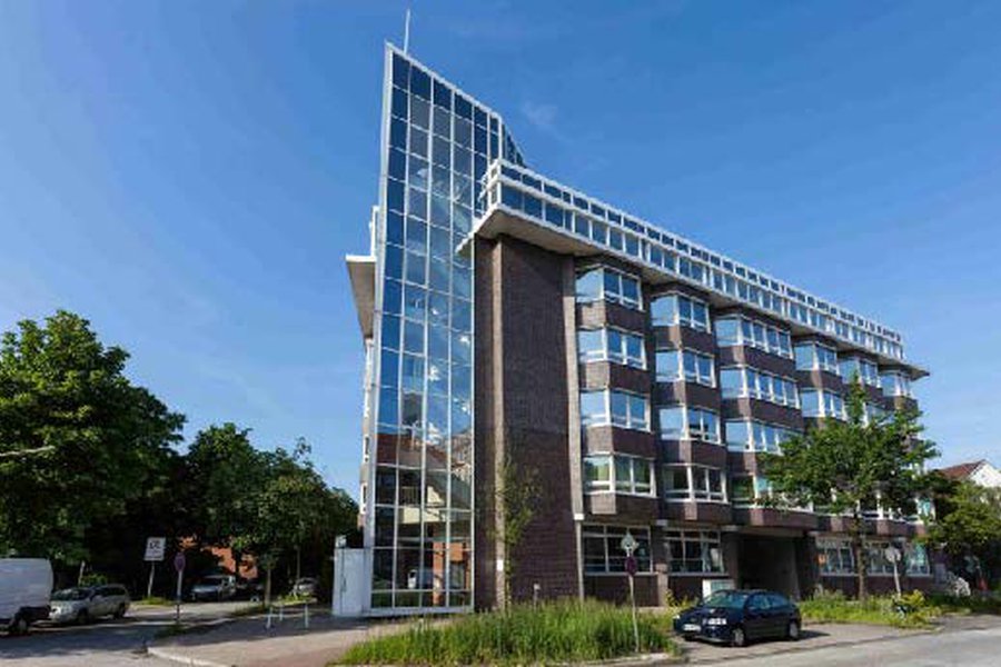 Seitenansicht des Gebäudes mit Glasgiebel und Backsteinfassade