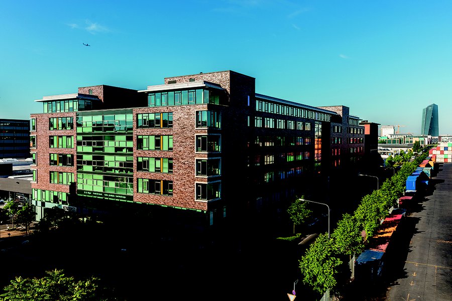 Außenansicht mit roter Backsteinfassade und grünen Fenstern