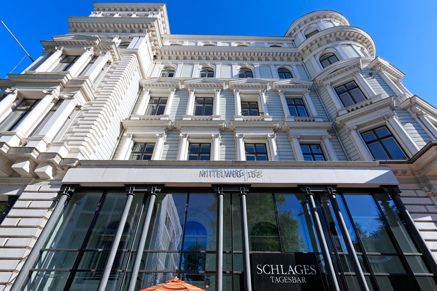 Historische Fassade mit verglastem Erdgeschoss und Schriftzug