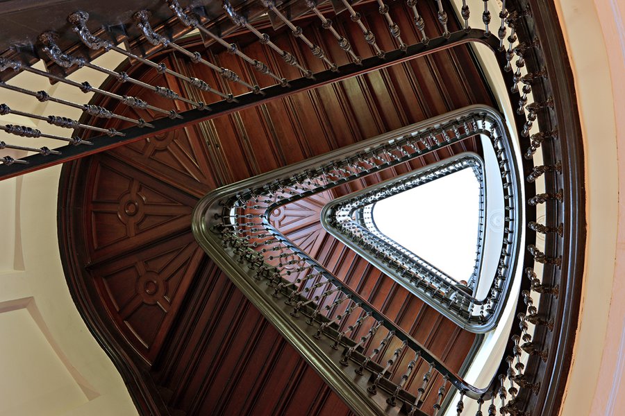 Blick ins Treppenhaus mit hölzernem Wendeltreppenaufgang