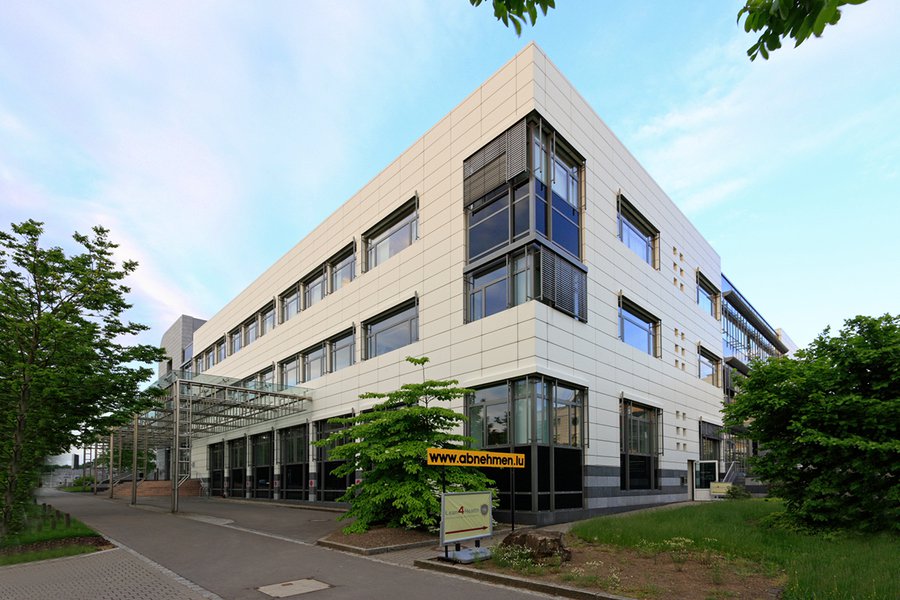 Eckansicht vom modernen Bürogebäude mit heller Fassade und Glasfronten