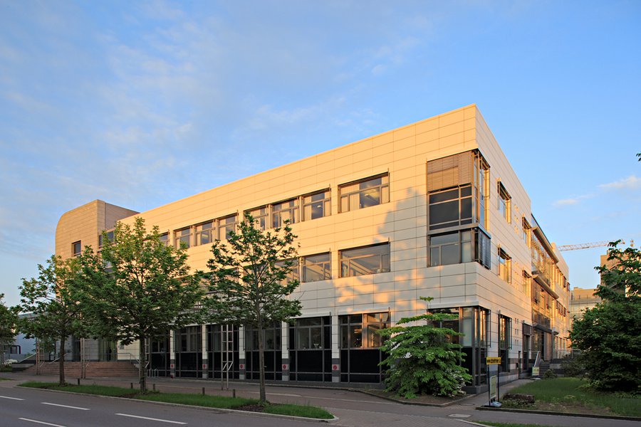 Seitenansicht des Bürogebäudes mit Bäumen im Vordergrund