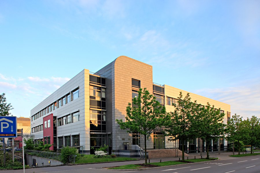 Eckansicht mit heller Steinverkleidung und großen Fenstern