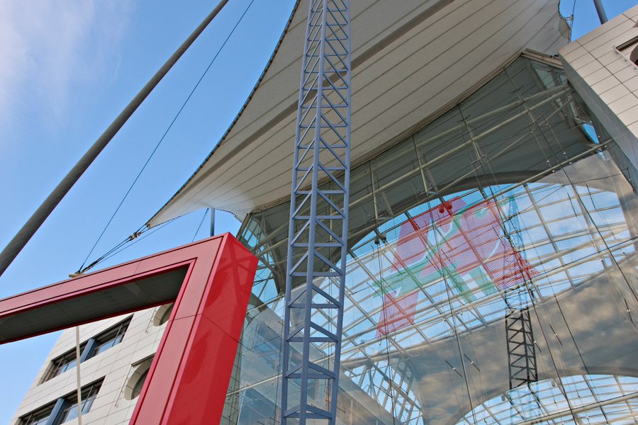 Detailaufnahme der Glasfassade mit rotem Stahlrahmen